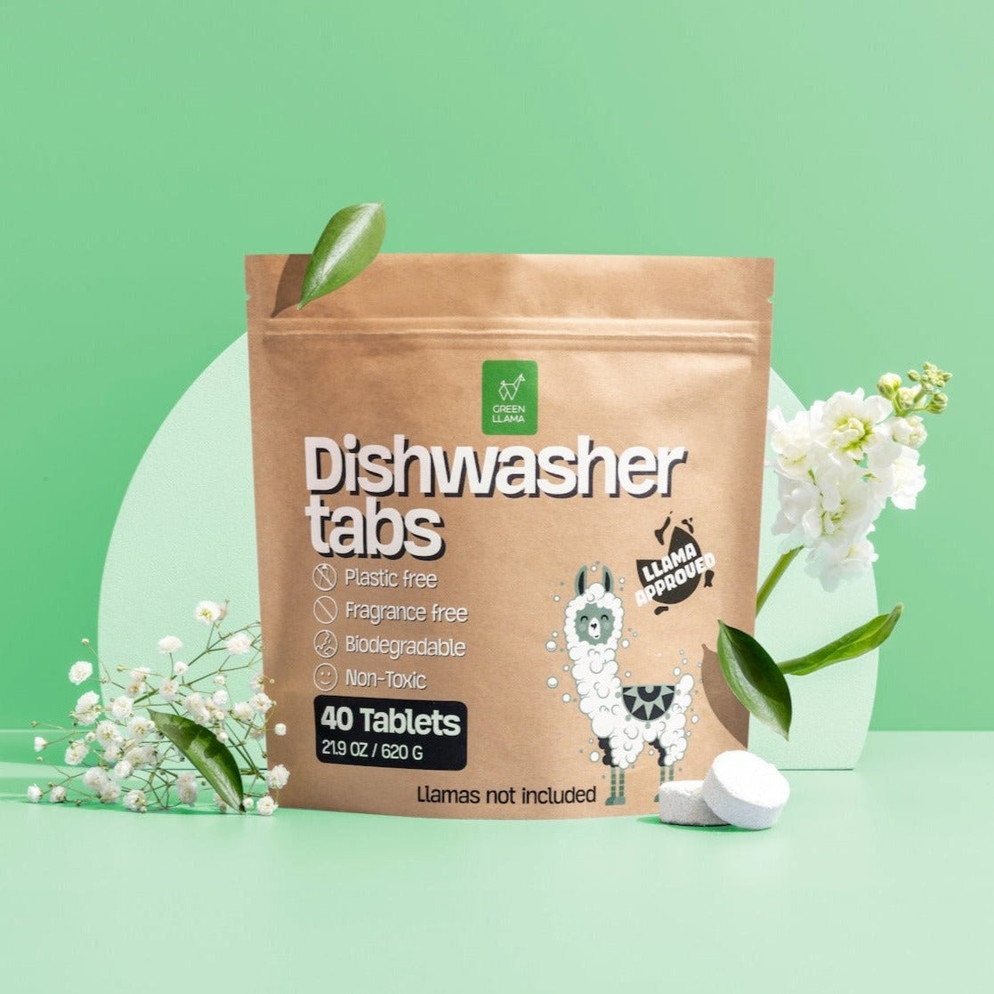 A brown resealable pouch labeled Dishwasher tabs with green icons stands upright. Featuring a cartoon llama, it’s surrounded by flowers, foliage, and two white tablets. Plant-powered cleaning from Green Llama’s The Ultimate Non-Toxic Home Bulk Bundle.