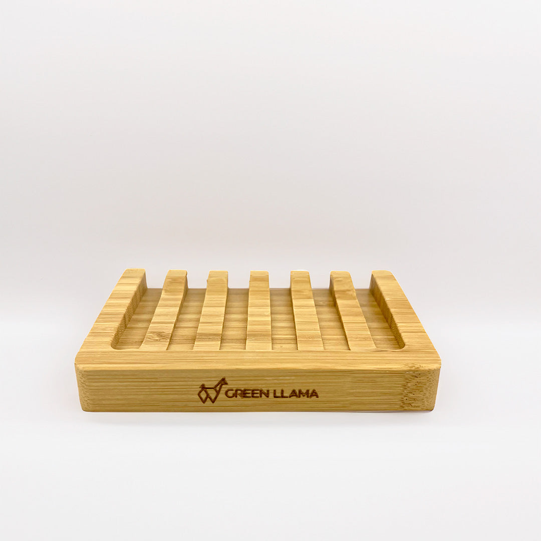 The Bamboo Dish Soap Holder with Signature Branding by Green Llama features evenly spaced slats and front engraving of the brand name and llama logo. This eco-friendly holder for soap bars is shown on a plain white background.