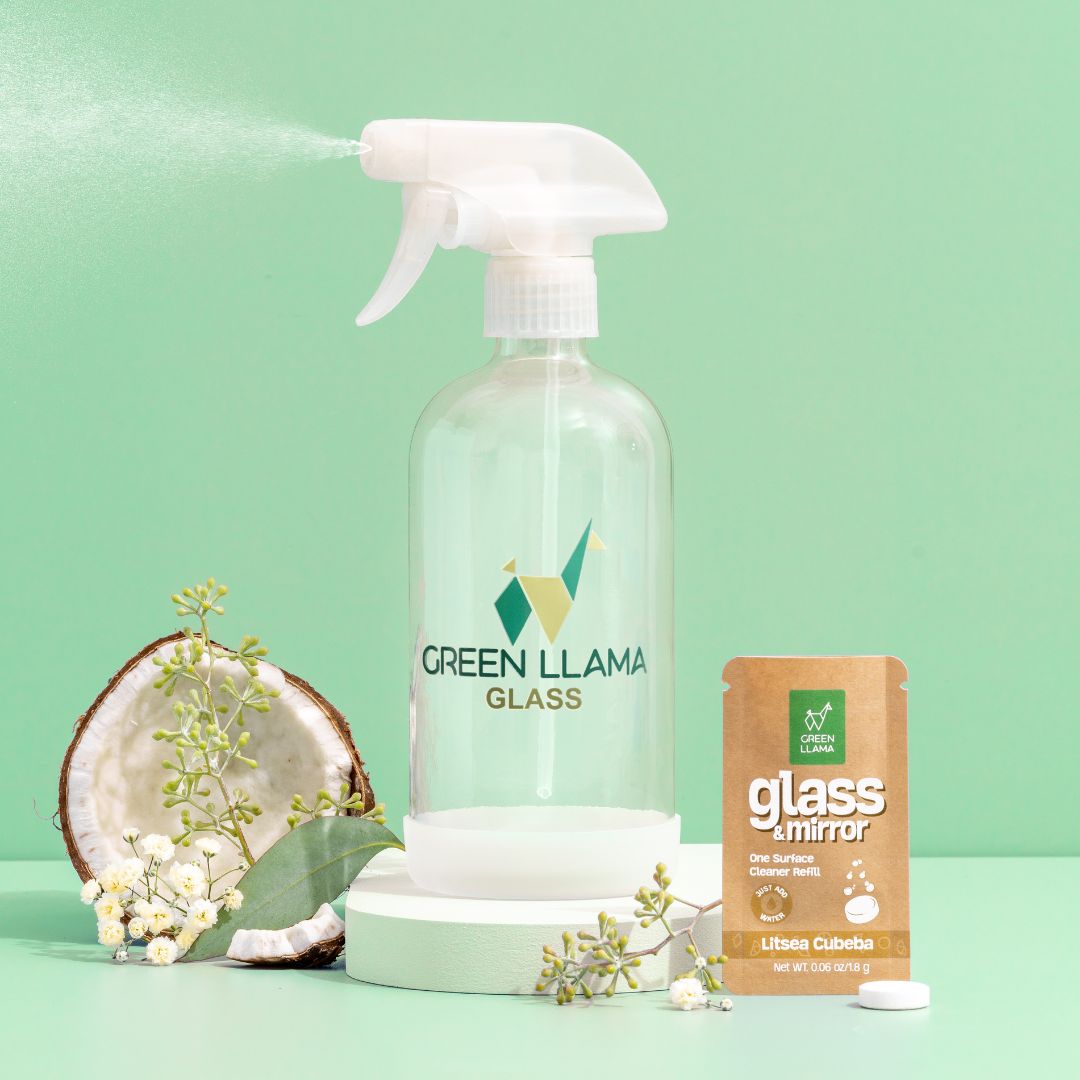A Green Llama Digital Gift Card, branded by Green Llama, is pictured on a green background next to a half coconut, delicate white flowers, leafy greens, and a brown packet labeled glass + mirror.